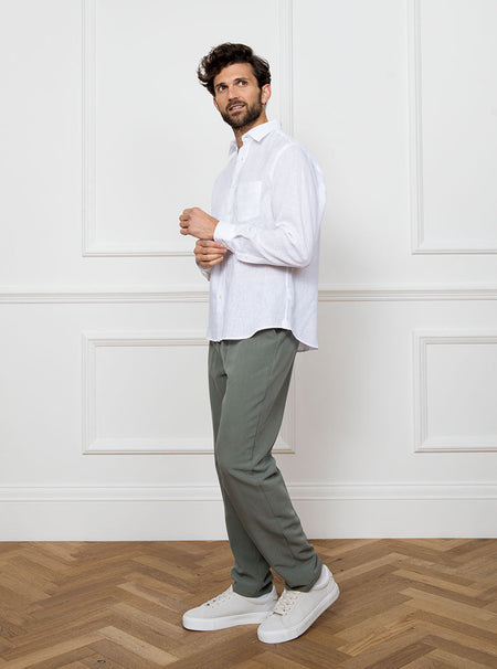 Man wearing white long sleeved shirt with a pocket detail made with 100% linen in a Thomas Mason fabric.